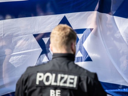 BERLIN, GERMANY - JUNE 01: A German policeman stands in front of counter demonstrators waving an Israeli flag as the annual Al-Quds march pass by (not pictured) on June 1, 2019 in Berlin, Germany. Critics accuse the Al-Quds marchers of anti-Semitism Quds Day was originally held in Iran and spread …