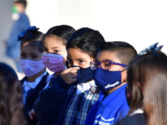 A students adjusts her facemask at St. Joseph Catholic School in La Puente, California on November 16, 2020, where pre-kindergarten to Second Grade students in need of special services returned to the classroom today for in-person instruction. - The campus is the second Catholic school in Los Angeles County to …