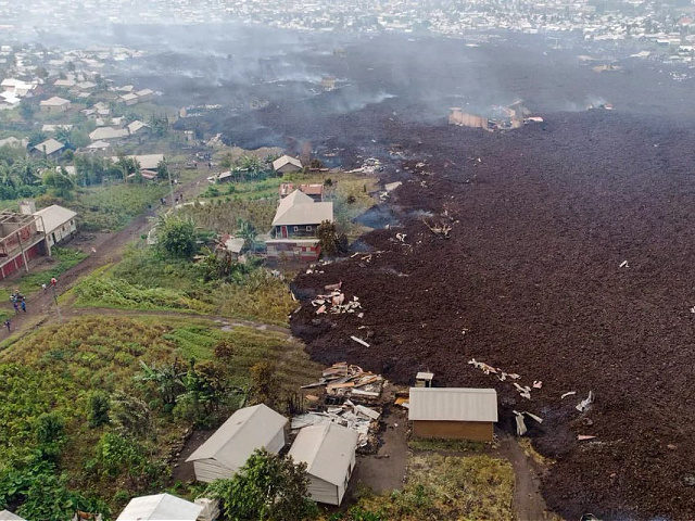 This aerial view shows debris engulfing buildings in Bushara village, Nyiragongo area, near Goma, on May 23, 2021, after a volcanic eruption of Mount Nyiragongo, that sent thousands fleeing during the night in eastern Democratic Republic of Congo. - A river of boiling lava from the eruption of Mount Nyiragongo …