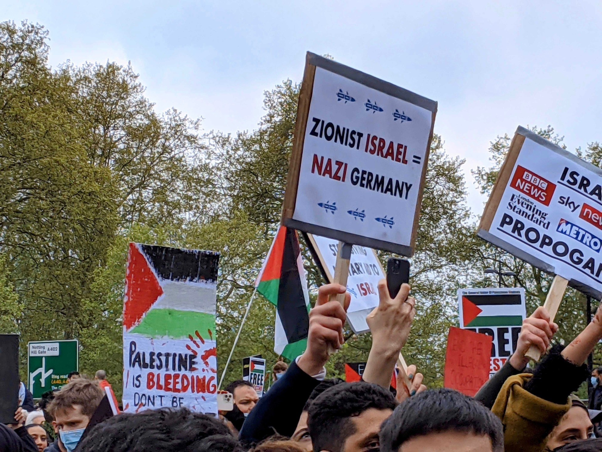 A protester is seen carrying a placard reading "Zionist Israel=Nazi Germany", at an anti-Israel protest in London. May 15th, 2021. Kurt Zindulka, Breitbart News