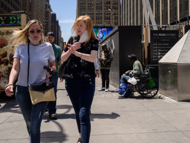 Pedestrians make their way along a street outside Penn station in Manhattan, New York on May 17, 2021. - From large corporations calling employees back to business district skyscrapers to the return of lunchtime lines at salad bars: signs that workers are returning to New York's offices, albeit in "hybrid" …