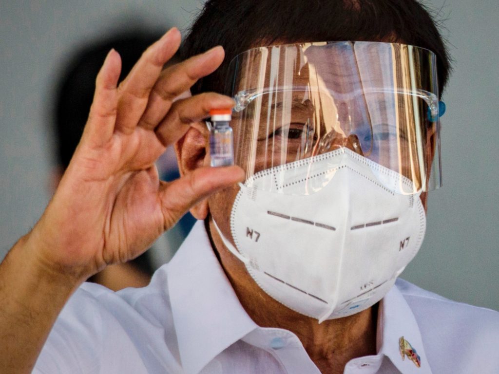 MANILA, PHILIPPINES - FEBRUARY 28: Philippine President Rodrigo Duterte holds up a vial of Sinovac Biotech's COVID-19 vaccines as he witnesses the arrival of a shipment of the vaccines at Ninoy Aquino International Airport on February 28, 2021 in Manila, Philippines. Philippine President Rodrigo Duterte witnessed the arrival of 600,000 doses of Sinovac Biotech vaccines donated by the Chinese government. Sunday's delivery marks the first time the Philippines received official coronavirus vaccines, the last country in ASEAN to do so. Government officials in the country faced backlash after admitting to receiving doses of smuggled vaccines as early as October of last year. (Photo by Ezra Acayan/Getty Images)