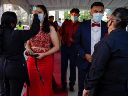 Grace Gardens Event Center employees check temperatures of young people attending prom at the Grace Gardens Event Center in El Paso, Texas on Friday, May 7, 2021. Around 2,000 attended the outdoor event at the private venue after local school districts announced they would not host proms this year. Tickets …
