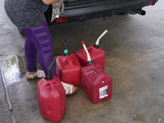 Elsa Enamorado calls her son to help her load cans of gasoline into her car at a Shell station, Wednesday, May 12, 2021, in Miami. State and federal officials are scrambling to find alternate routes to deliver gasoline in the Southeast U.S. after a hack of the nation's largest fuel …