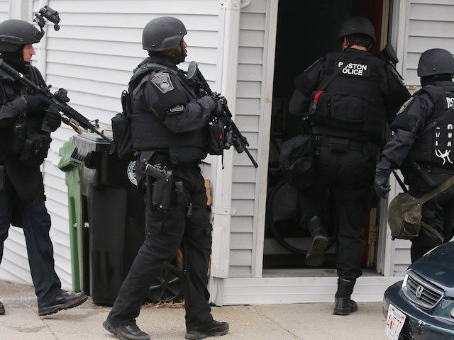 SWAT team members search for one remaining suspect at a residential building on April 19, 2013 in Watertown, Massachusetts. Earlier, a Massachusetts Institute of Technology campus police officer was shot and killed at the school's campus in Cambridge. A short time later, police reported exchanging gunfire with alleged carjackers in …