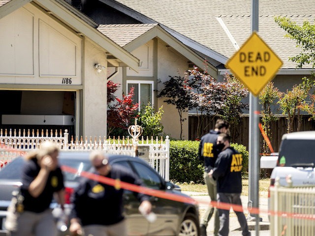 FBI agents approach a home, rear, being investigated in connection to a shooting at a Sant