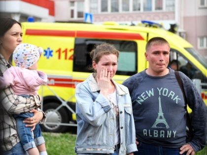 People react at a makeshift memorial for victims of the shooting at School No. 175 in Kazan on May 11, 2021. - At least nine people, most of them children, were killed on May 11, 2021 when a lone teenage gunman opened fire at a school in the central Russian …
