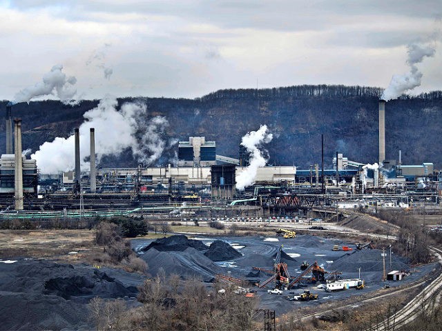 A coke storage area is seen as steam rises from the quench towers at the US Steel Clairton Works on January 21, 2020, in Clairton, Pennsylvania. - White plumes of smoke billow above western Pennsylvania's rolling hills into the frigid air as scorching ovens bake coal, which rolls in by …