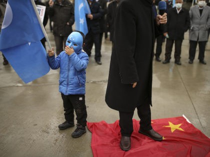 Protesters from the Uyghur community living in Turkey step on a China's flag during a protest against the visit of China's Foreign Minister Wang Yi to Turkey, in Istanbul, Thursday, March 25, 2021. Hundreds of Uyghurs staged protests in Istanbul and the capital Ankara, denouncing Wang Yi's visit to Turkey …