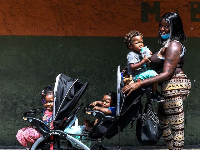Monisha Lanir (29), poses with her three children in a stroller at a roadside sidwalk in a low income, mostly African-American neighbourhood in Miami, on April 17, 2020. - Lanir was working for three years and for almost a month has had no job. "I lost my job, I was …