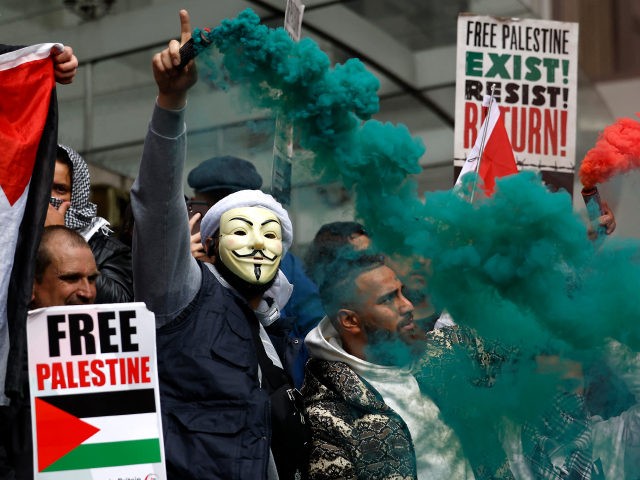 TOPSHOT - Pro-Palestinian activists and supporters let off smoke flares, wave flags and carry placards during a demonstration in support of the Palestinian cause as violence escalates in the ongoing conflict with Israel, outside the Israeli embassy in central London on May 15, 2021. (Photo by Tolga Akmen / AFP) …
