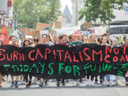 Student of the 'Fridays for Future' climate movement protest with a banner reading 'Burn capitalism - not coal' in Cologne, Germany, Friday, July 12, 2019. (Rolf Vennenbernd/dpa via AP)