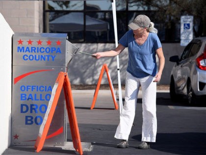 People deposit their mail-in ballots for the US presidential election at a ballot collection box in Phoenix, Arizona on October 18, 2020. - Arizona is one of the eight critical swing states, along with Florida, Georgia, Michigan, Minnesota, North Carolina, Pennsylvania and Wisconsin that will determine the outcome of the …