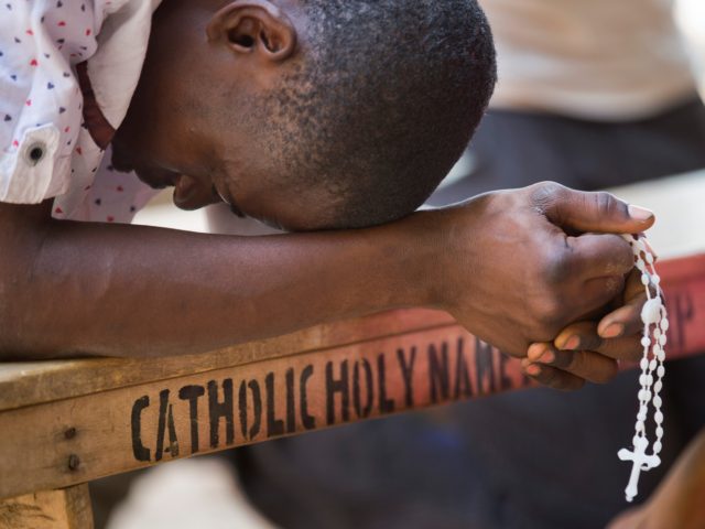 A Nigerian man prays in the yard of the St Charles Catholic Church, scene of a 2014 bomb attack blamed on Boko Haram Islamic insurgents, in the mainly Christian Sabon Gari neighborhood of Kano, northern Nigeria on Palm Sunday, March 29, 2015. Normally the church would be packed with up …