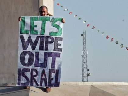 An Iranian man holds a placard during a march to condemn the ongoing Israeli air strikes o