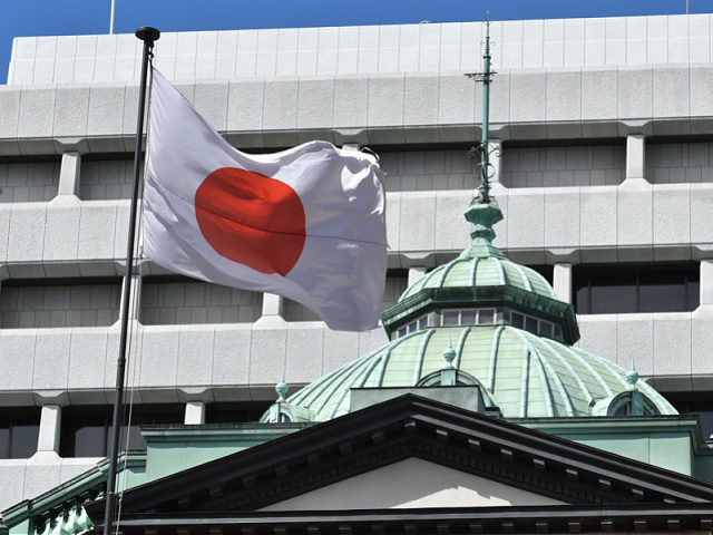 The Japanese national flag is seen at the Bank of Japan headquarters in Tokyo on March 16,