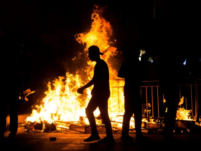 JERUSALEM, ISRAEL - MAY 08: Palestinians stand next to a burning barricade during clashes