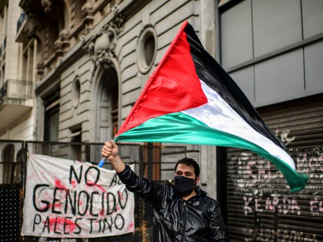 A man holds a Palestian flag during a demonstration in support of Palestinians during an anti-Israel protest rally near the Israel embassy, in Buenos Aires, on May 17, 2021 (Photo by RONALDO SCHEMIDT / AFP) (Photo by RONALDO SCHEMIDT/AFP via Getty Images)