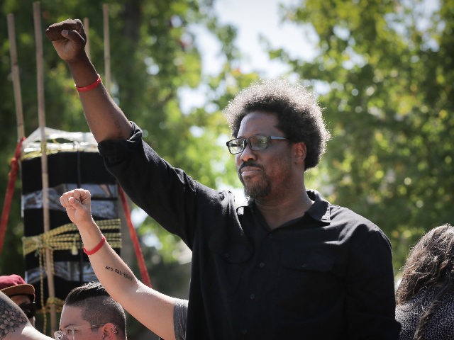 BERKELEY, CA - AUGUST 27: Comedian W. Kamau Bell raises his fist from a truck as people be