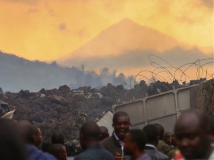 Residents check the damages caused by lava from the overnight eruption of Mount Nyiragongo, seen in background, in Buhene, on the outskirts of Goma, Congo in the early hours of Sunday, May 23, 2021. Congo's Mount Nyiragongo erupted for the first time in nearly two decades Saturday, turning the night …