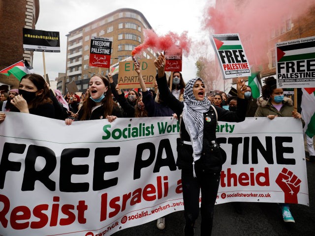 Pro-Palestinian activists and supporters let off smoke flares, wave flags and carry placards during a demonstration in support of the Palestinian cause as violence escalates in the ongoing conflict with Israel, in central London on May 15, 2021. (Photo by Tolga Akmen / AFP) (Photo by TOLGA AKMEN/AFP via Getty …