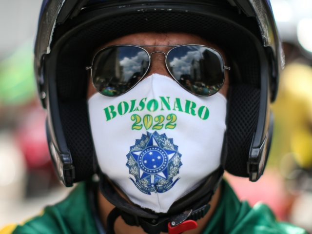 SAO PAULO, BRAZIL - MARCH 14: A supporter of Brazilian President Jair Bolsonaro protest with a face mask that reads "Bolsonaro 2022" during a motorcade and demonstration in favor of the government amidst the coronavirus (COVID-19) pandemic in Avenida Paulista on March 14, 2021 in Sao Paulo, Brazil. Brazil has …