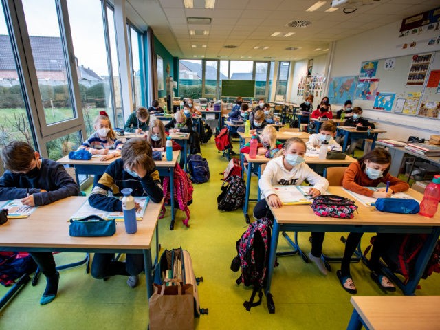 Illustration picture shows children wearing a mouth mask in class, at primary school De Va
