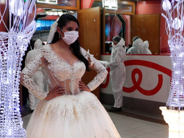 A woman in a bridal dress poses for a photo in a ballroom after a mock wedding during the partial lifting of restrictions amid the COVID -19 pandemic in La Paz, Bolivia, Wednesday, Oct. 7, 2020. The mock wedding is part of an effort by owners of ballrooms and dance …