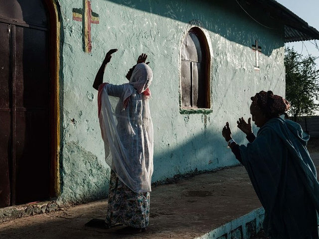 TOPSHOT - An Ethiopian refugee who fled the Tigray conflict prays during Sunday Mass at an Ethiopian Orthodox church building built by former Ethiopian refugees, at the village next to Um Raquba refugee camp in Gedaref, eastern Sudan, on December 6, 2020. - Some 400 Orthodox Christian believers attended the …