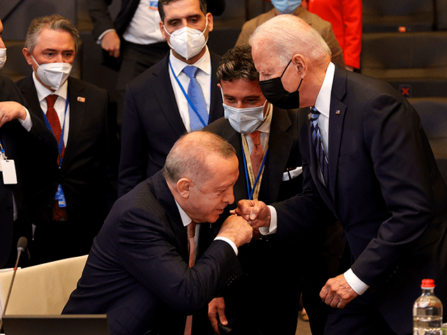 Turkey's President Recep Tayyip Erdogan, center, fist bumps with U.S. President Joe Biden, right, as he stands up to greet him during a plenary session at a NATO summit in Brussels, Monday, June 14, 2021. U.S. President Joe Biden is taking part in his first NATO summit, where the 30-nation …