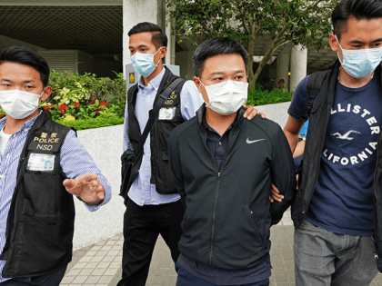 Ryan Law, second from right, Apple Daily's chief editor, is arrested by police officers in Hong Kong Thursday, June 17, 2021. Hong Kong police on Thursday morning arrested the chief editor and four other senior executives of Apple Daily under the national security law on suspicion of collusion with a …