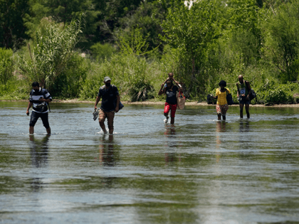 A group of migrants walk across the Rio Grande on their way to turn themselves in upon crossing the U.S.-Mexico border, Tuesday, June 15, 2021, in Del Rio, Texas. U.S. government data shows that 42% of all families encountered along the border in May hailed from places other than Mexico, …