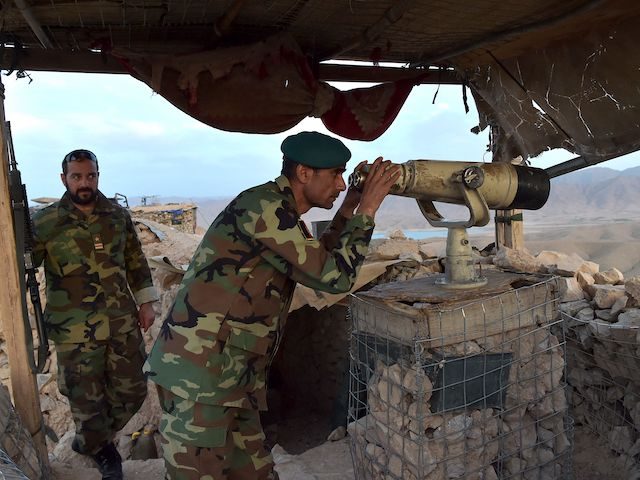 In this photograph taken on March 23, 2021, Afghan National Army (ANA) commander Dost Nazar Andarabi keeps watch with binoculars at an outpost set up against Taliban fighters in Kajaki, northeast of Helmand Province. - In the heart of territory under siege from the Taliban, one of Afghanistan's most important …