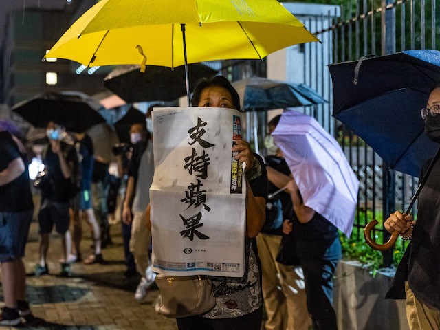 A supporter holds up a copy of the Apple Daily newspaper outside of their offices on June 23, 2021 in Hong Kong, China. Hong Kong’s largest pro-democracy newspaper announced it would be printing its final issue on Thursday after its offices were raided last week over allegations that reports had breached a controversial national security law. (Photo by Anthony Kwan/Getty Images)