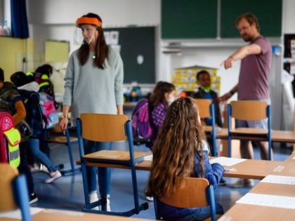 Teachers give instructions to their students in a classroom of the Petri primary school in Dortmund, western Germany, on June 15, 2020 amid the novel coronavirus COVID-19 pandemic. - From June 15, 2020, all children of primary school age in the western federal state of North Rhine-Westphalia will once again …