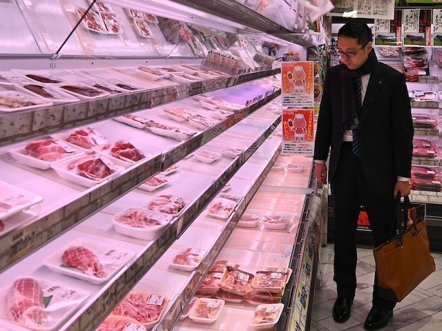 A man looks at meat on nearly empty shelves in a supermarket in Tokyo on March 27, 2020. (Photo by Philip FONG / AFP) (Photo by PHILIP FONG/AFP via Getty Images)