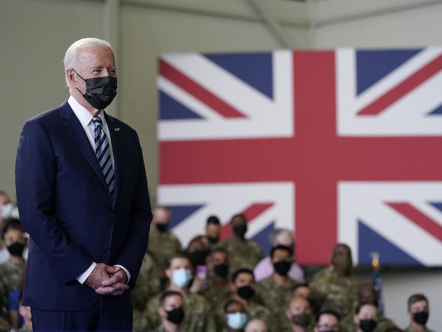 President Joe Biden listens as first lady Jill Biden speaks to American service members at