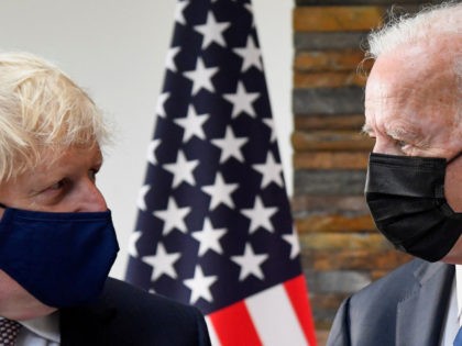 Britain's Prime Minister Boris Johnson (L) and US President Joe Biden, wearing face coverings due to Covid-19, view documents relating to the Atlantic Charter prior to a bi-lateral meeting at Carbis Bay, Cornwall on June 10, 2021, ahead of the three-day G7 summit being held from 11-13 June. - G7 …