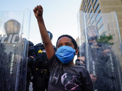 ATLANTA, GA - MAY 31: A young boy raises his fist for a photo by a family friend during a