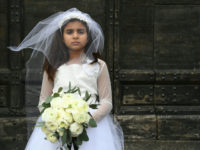 A young actress plays the role of Giorgia, 10, forced to marry Paolo, 47, during a happening organised by Amnesty International to denounce child marriage, on October 27, 2016 in Rome. (Photo by GABRIEL BOUYS / AFP) (Photo by GABRIEL BOUYS/AFP via Getty Images)