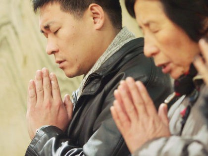 BEIJING, CHINA - DECEMBER 24: Catholis pray during a Christmas Mass at a church on December 24, 2004 in Beijing, China. Though Christmas is not officially celebrated in China, the holiday is becoming increasingly popular as Chinese adopt more Western ideas and festivals. (Photo by Guang Niu/Getty Images) *** Local …