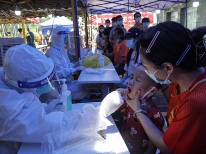This photo taken on May 30, 2021 shows a child (2nd R) receiving a nucleic acid test for the Covid-19 coronavirus in Guangzhou in China's southern Guangdong province. - China OUT (Photo by STR / AFP) / China OUT (Photo by STR/AFP via Getty Images)