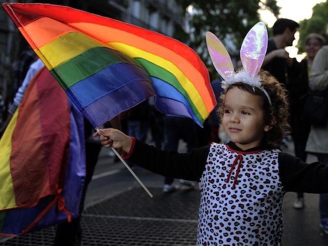A girl holds a Rainbow flag of the LGBT movement during the XXI Gay Pride Parade, at Mayo square in Buenos Aires on November 10, 2012. AFP PHOTO / Alejandro PAGNI (Photo credit should read ALEJANDRO PAGNI/AFP via Getty Images)