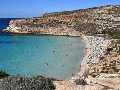 Tourists enjoy the beach of the Isola dei Conigli (Rabbit Island) in Lampedusa on September 27, 2018. - Five years after the worst shipwreck of its history, the largest island of the Italian Pelagie Islands in the Mediterranean Sea, Lampedusa relies on the flood of tourists to make a fresh …