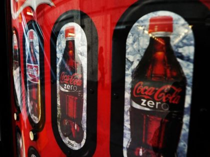 A woman (C) is reflected on a Coca Cola vending machine in Arlington, Virgina, on February
