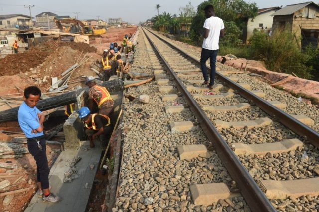 Workers try to cast a section of the new standard gauge railway line under construction from Iju in Lagos to Abeokuta, Ogun State in southwest Nigeria, on February 7, 2019. - The passenger train service which is designed to boost economic activites and ease movement of passengers by rail from …