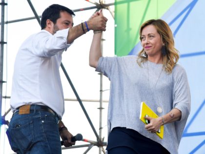 Leader of Italy's conservative party Brothers of Italy, Giorgia Meloni (R) taps hand with head of Italy's far-right League party, Matteo Salvini as she steps on the stage to speak during a rally of Italy's far-right League party, conservative Brothers of Italy party and liberal-conservative Forza Italia party against the …