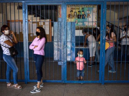 Parents of students are seen at the "Tito Salas" public High School during the 2020-2021 school year registration day in Las Minas de Baruta neighborhood, Caracas, on October 7, 2020, amid the new coronavirus pandemic. - With students that have to catch internet in the streets and teachers who earn …