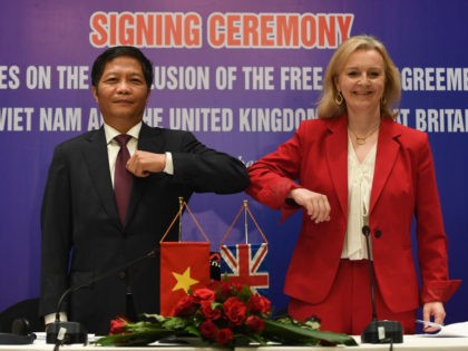 Vietnam's Minister of Industry and Trade Tran Tuan Anh (L) and Britain's International Trade Secretary Liz Truss elbow bump after signing a free trade agreement between the two countries in Hanoi on December 11, 2020. (Photo by Nhac NGUYEN / AFP) (Photo by NHAC NGUYEN/AFP via Getty Images)