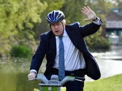 British Prime Minister Boris Johnson rides a bike on the towpath of the Stourbridge canal during a Conservative party local election visit in Stourbridge, central England on May 5, 2021. - Local elections take place in England on Thursday. (Photo by Rui Vieira / POOL / AFP) (Photo by RUI …